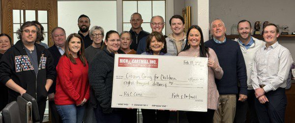 Group photo of Citizens Caring for Children team holding a donation check from Rich & Cartmill.