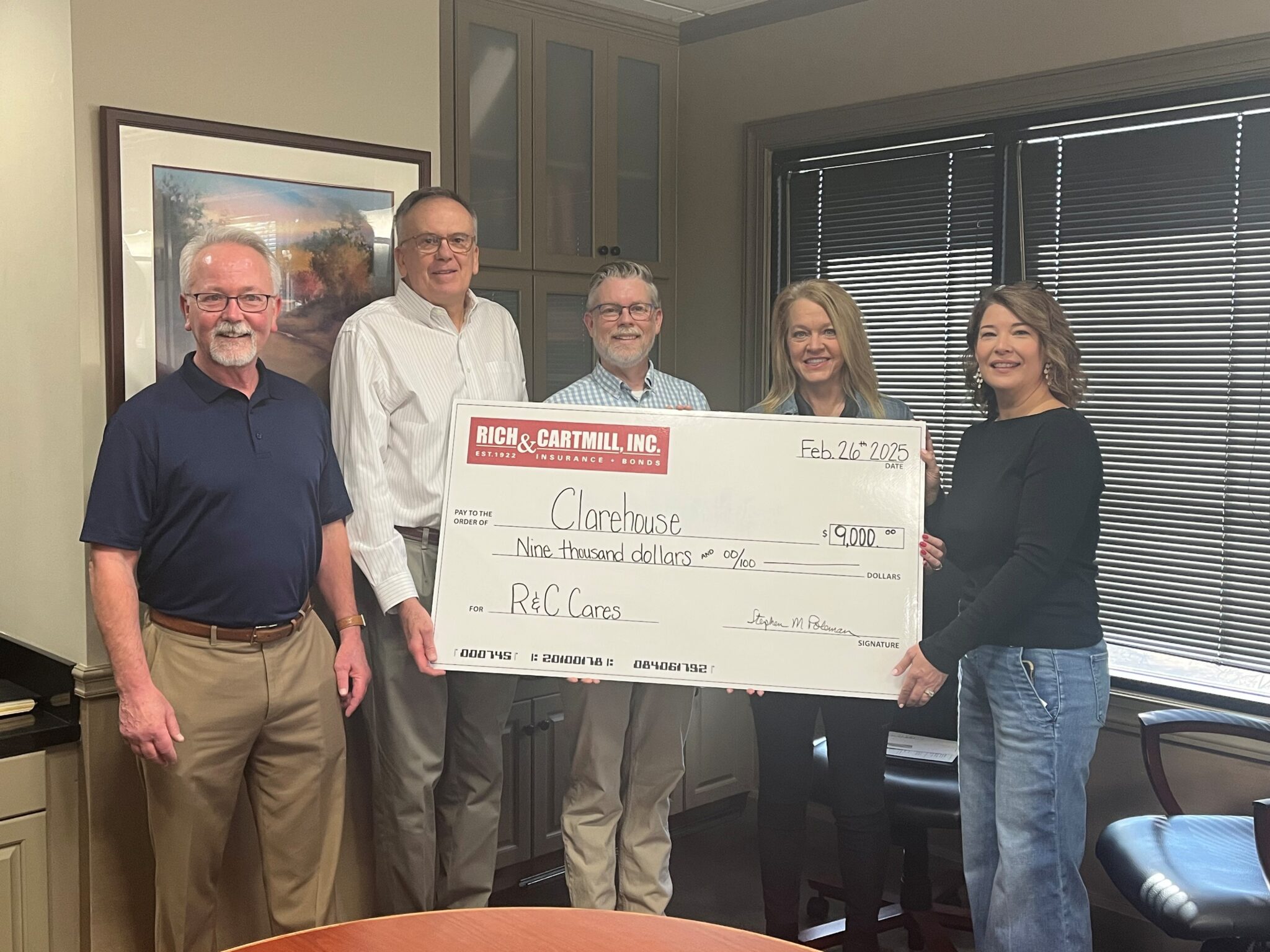 Group photo of Clarehouse team holding donation check from Rich & Cartmill's R&C Cares