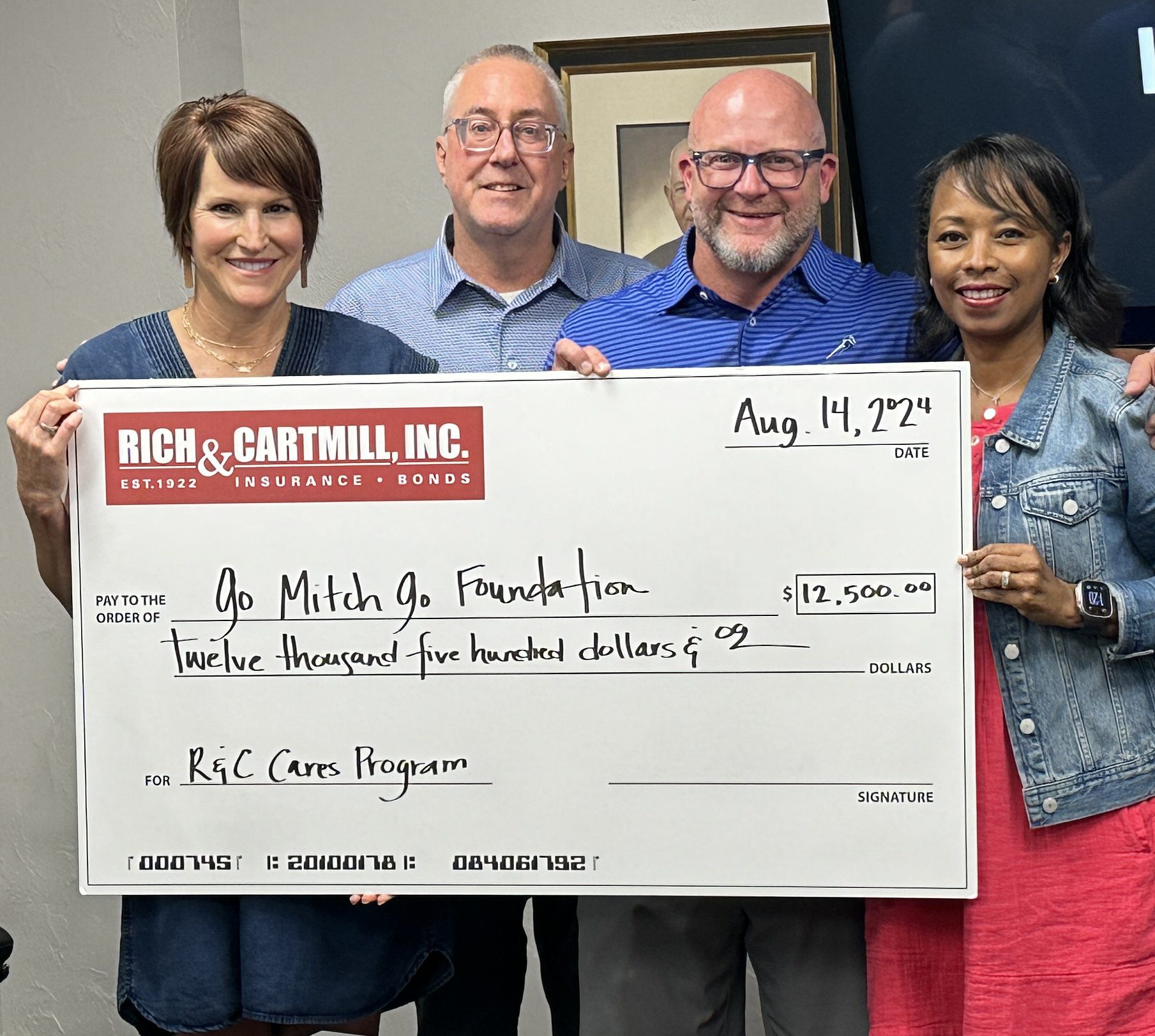 Group photo of the Go Mitch Go Foundation holding a check from R&C cares.